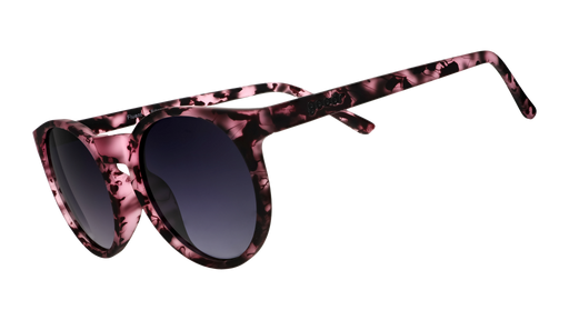 Three-quarter angle view of round translucent pink tortoiseshell frames with black gradient lenses.