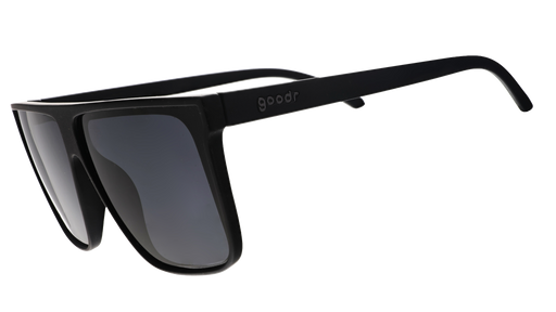 Three-quarter view of black wide-fit, oversized flat-top sunglasses with black non-reflective lenses.