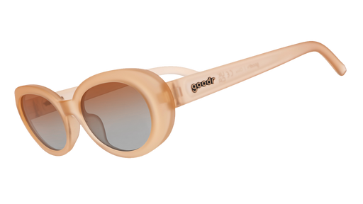 Three-quarter angle view of translucent pale peach oval Beat G sunglasses with orange-gold gradient lenses. 