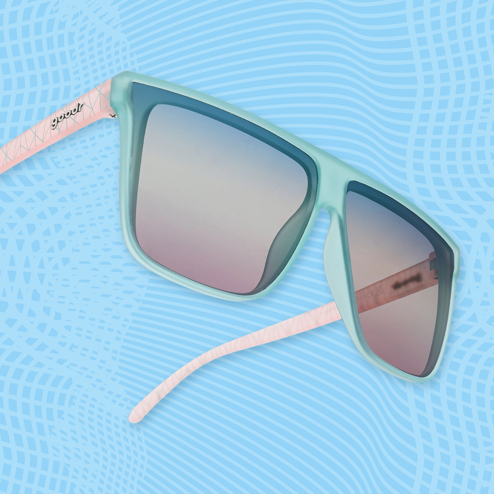 Side view of light blue sunglasses with pink-patterned temple arms and blue-pink gradient lenses.