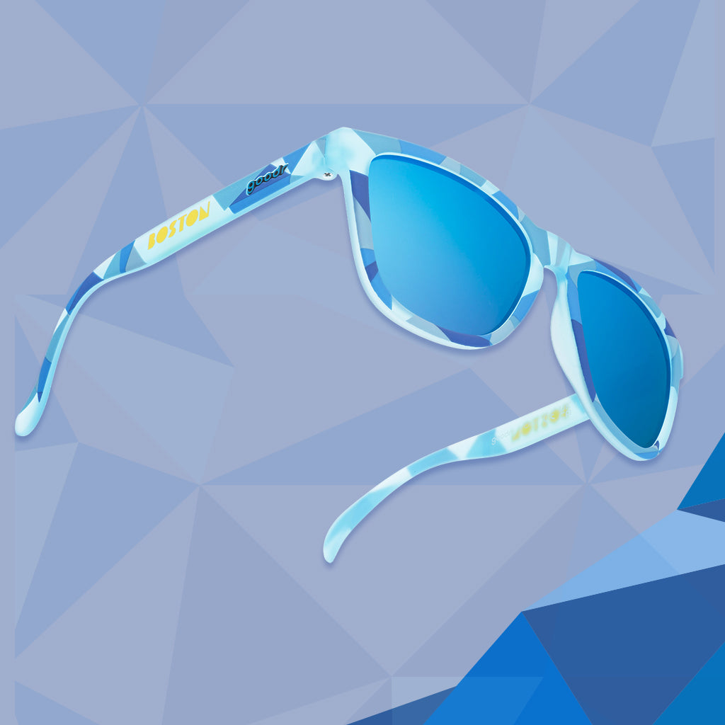 Three-quarter angle view of light blue shades w/geometric pattern, Boston printed on temples+blue reflective lenses.