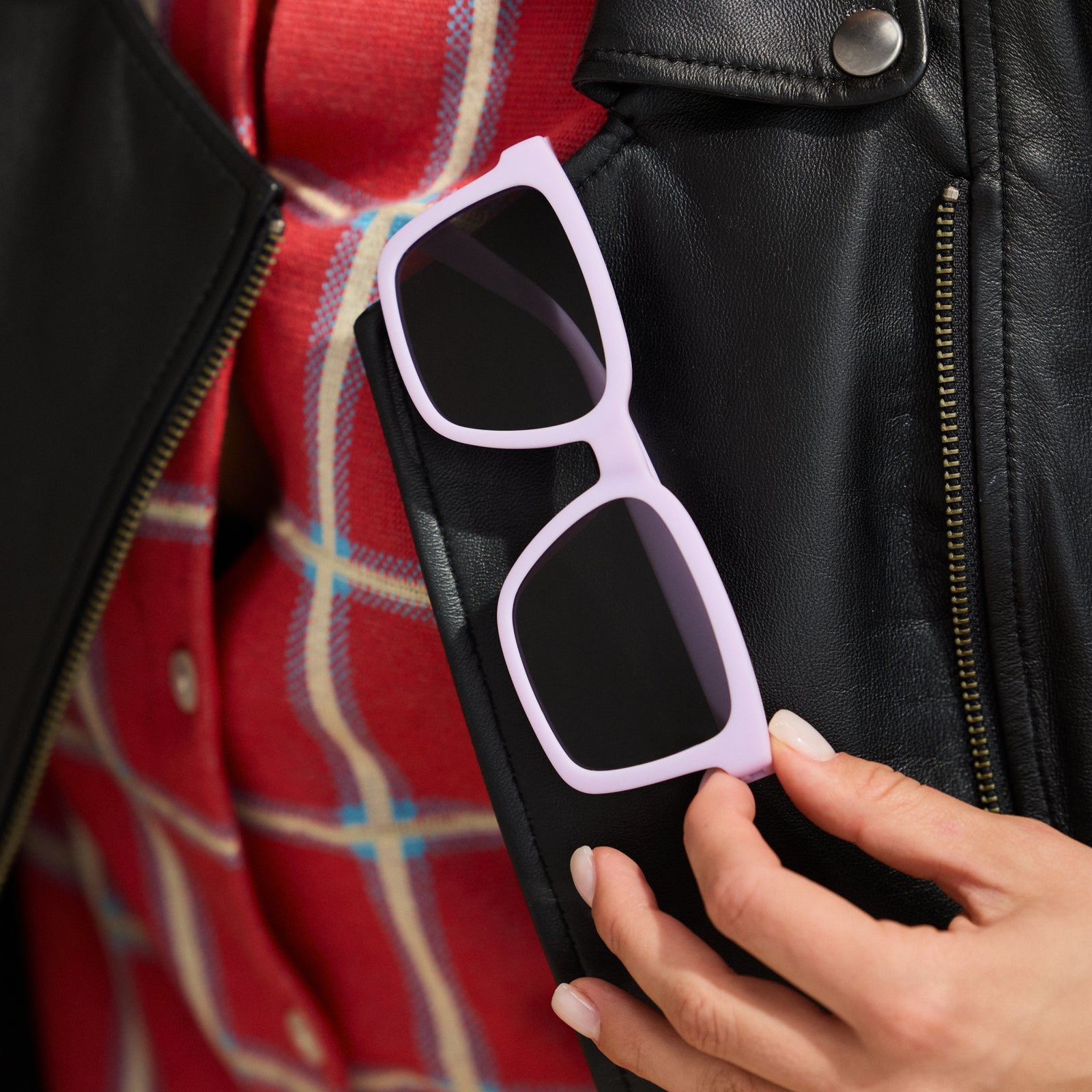 Lavender square Slate G sunglasses photographed from behind sitting sideways on a green velvet surface.
