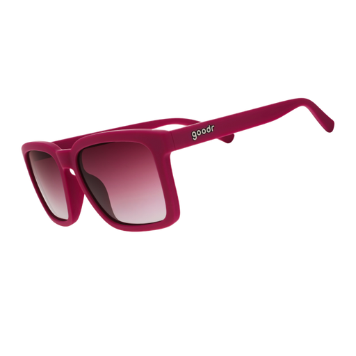 Three-quarter angle view of purple sunglasses w/ a square silhouette & purple gradient lenses tilted down.