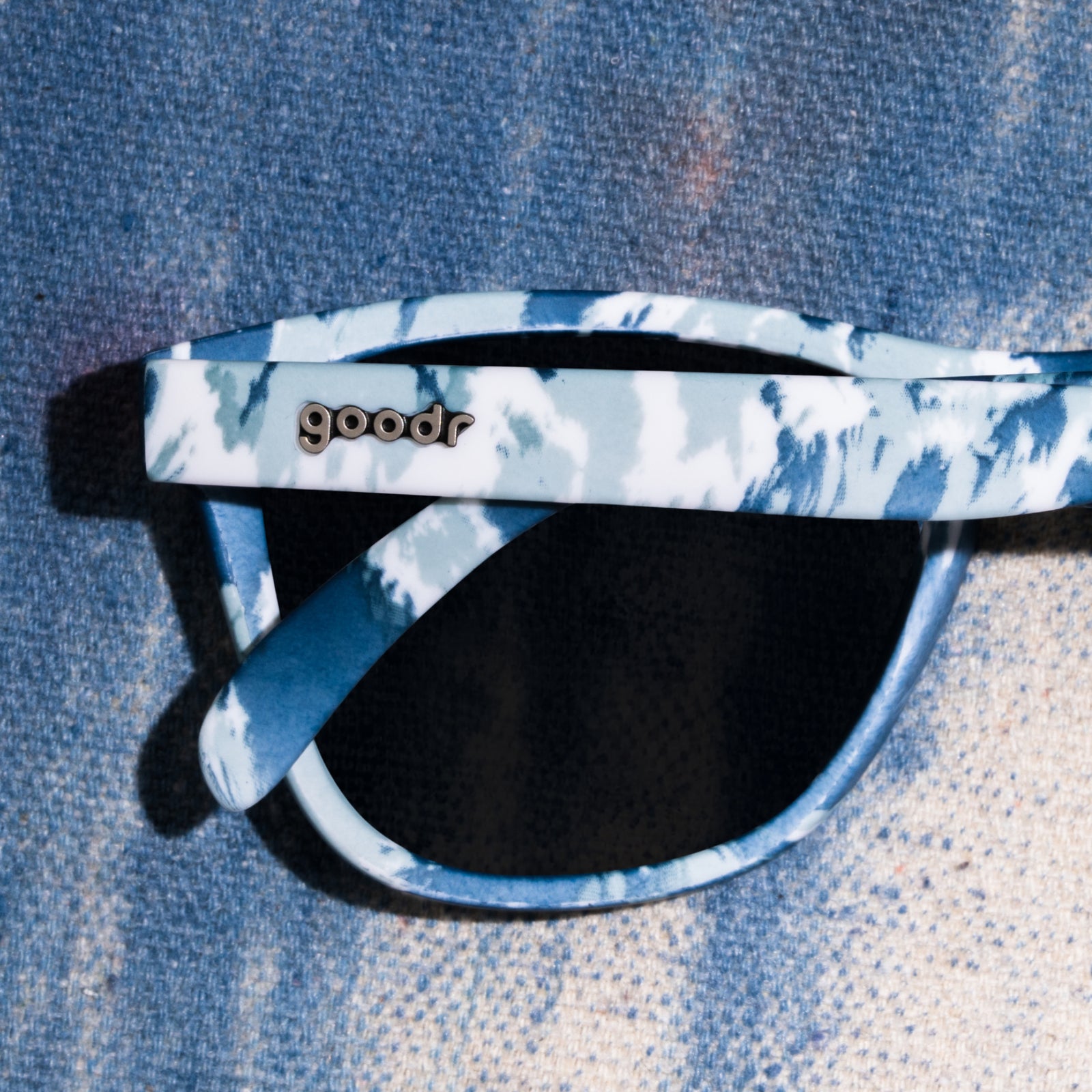 Front view of tonal blue on blue tie-dye sunglasses in a classic frame shape with ice blue reflective lenses.