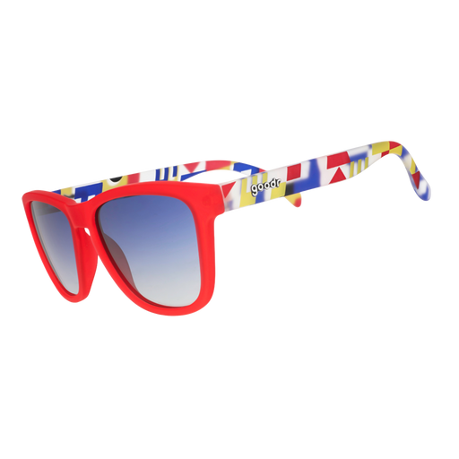 Three-quarter angle view of red sunglasses with multi-colored arms depicting maritime signal flags, and blue gradient lenses.