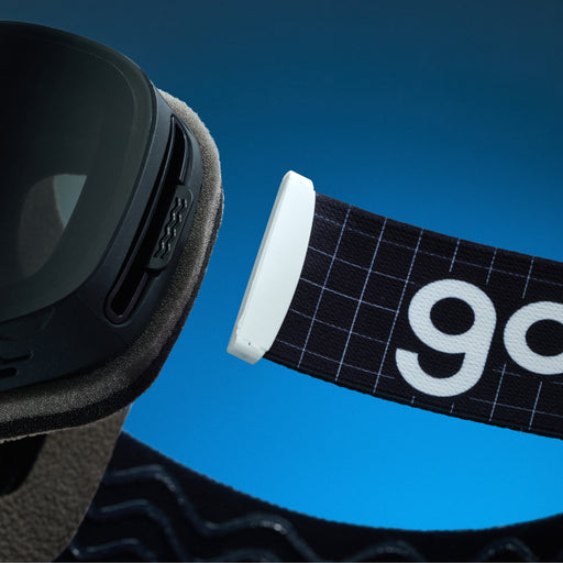 Close-up of black grid-pattern goodr goggle strap attached to black ski goggles.